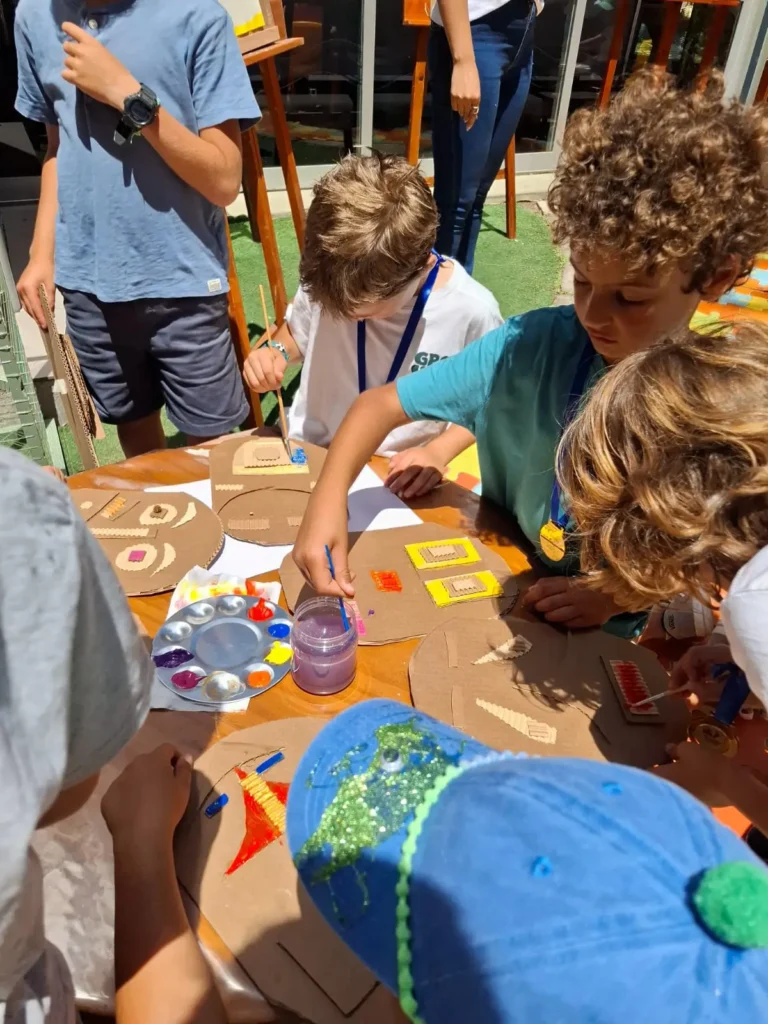 Niños decorando piezas de cartón con pintura durante el Family Day del Colegio Woodside